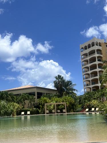 a building and a swimming pool in front of a building at Luxury Marina & Sea View Condo at Porto Cupecoy St Maarten in Lowlands