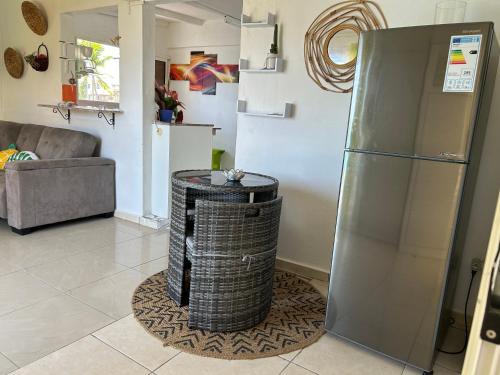 a living room with a refrigerator and a trash can at Sunrise in Le Moule