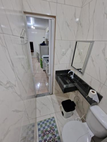 a bathroom with a sink and a toilet and a mirror at FLAT CENTRAL- Ar-Condicionado-Estacionamento in Feira de Santana
