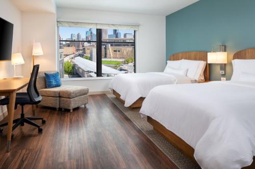 ミネアポリスにあるElement Minneapolis Downtown North Loopのベッド2台、デスク、窓が備わるホテルルームです。