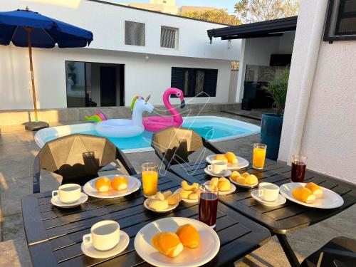 ein Tisch mit Tellern mit Orangen und einem Pool in der Unterkunft Casa Temporada Rio Quente (Em frente ao Hot Park) in Rio Quente