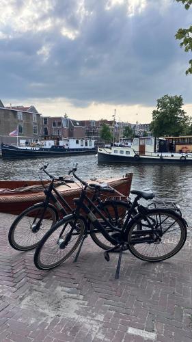 two bikes parked next to a river with boats at The Harbour Leiden in Leiden