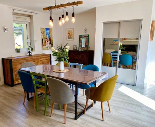 a dining room with a wooden table and chairs at Petit Launay - proche Rennes in Vezin-le-Coquet