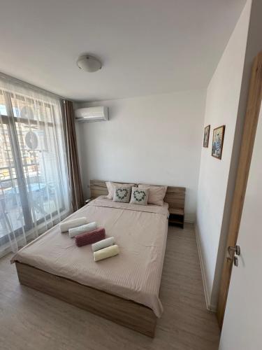 Un dormitorio con una cama y una ventana grande. en Apartament Diana, en Pomorie