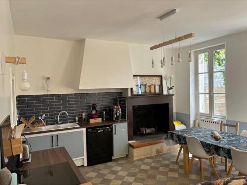 une cuisine avec une table et une salle à manger dans l'établissement Maison de campagne - L'escale bucolique, à Villefranche-de-Longchat