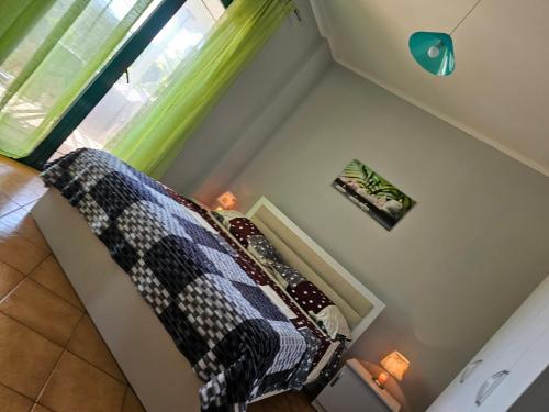 a bedroom with a bed and a window with green curtains at Kuqa Rent House in Ksamil