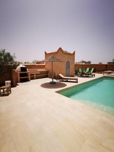 a patio with a swimming pool and a house at Villa Douira avec piscine, proche d'Essaouira in Essaouira