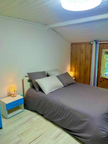 une chambre avec un grand lit et une table de chevet dans l'établissement Appartement dans maison familiale, à Bellevaux