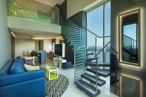 a living room with a blue couch and a staircase at W Mexico City in Mexico City