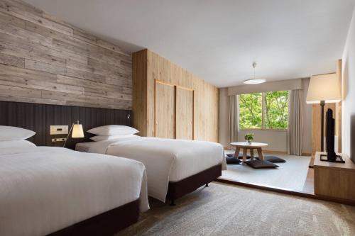 a hotel room with two beds and a window at Courtyard by Marriott Hakuba in Hakuba