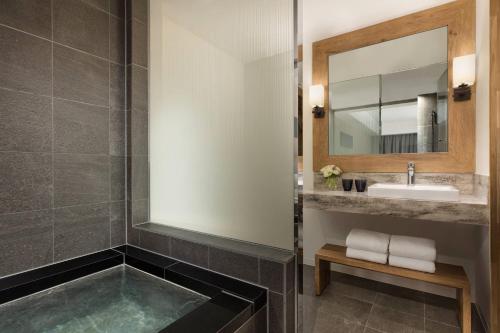 a bathroom with a sink and a mirror at Courtyard by Marriott Hakuba in Hakuba
