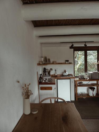 a kitchen with a wooden table and a window at Stanley Island in Plettenberg Bay
