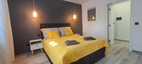 a bedroom with a bed with yellow blankets and pillows at Baltivia ADULTS ONLY in Świnoujście