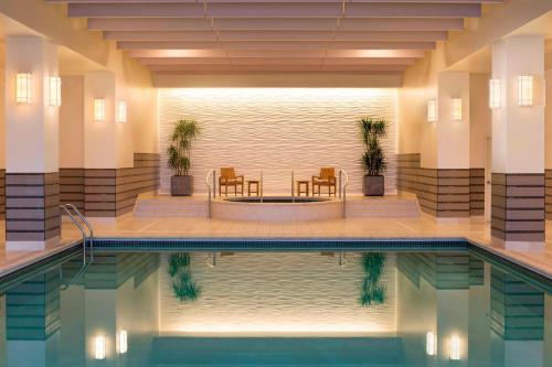 a pool in a hotel with chairs and a table at The Westin Edina Galleria in Edina