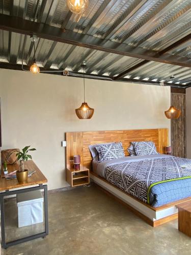 a bedroom with a bed and a table and lights at Adama Biohotel in Calima