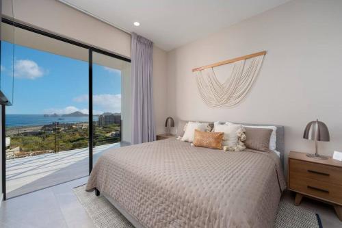 a bedroom with a bed and a large window at Best view rooftop with heated jacuzzi in Cabo San Lucas