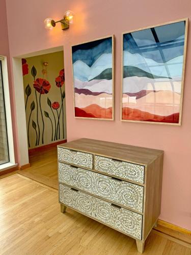 a dresser in a room with two paintings on the wall at Unmatched Ocean Beach and Mountain Views Family-Friendly Retreat in Moss Beach