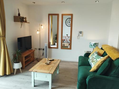 a living room with a green couch and a coffee table at The Green Top flat with parking included amazing views and perfect location in Plymouth