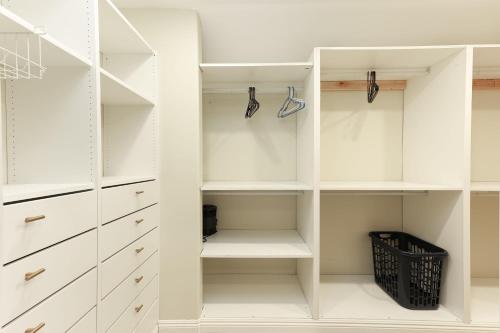 a white walk in closet with white cabinets at Pristine Poway Retreat in Poway