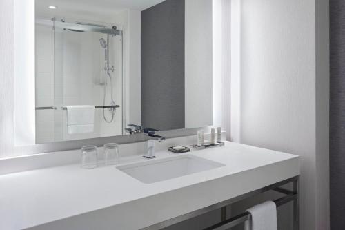 a white bathroom with a sink and a mirror at Halifax Marriott Harbourfront Hotel in Halifax