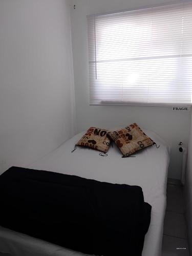 a bed in a room with two pillows on it at A 5 minutos GNP Hostal Foro Sol Palacio Deportes Aeropuerto A PET FRIENDLY se aceptan mascotas bajo peticion in Mexico City
