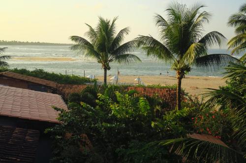 a view of a beach with palm trees and the ocean at Pousada Nascente do Sol in Ilha de Boipeba