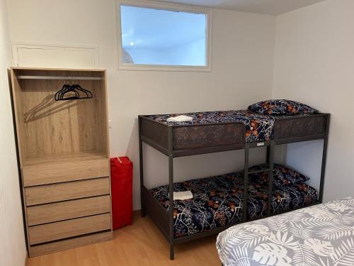 Un dormitorio con dos literas y una ventana. en Au Coin Champenois Epernay, en Épernay