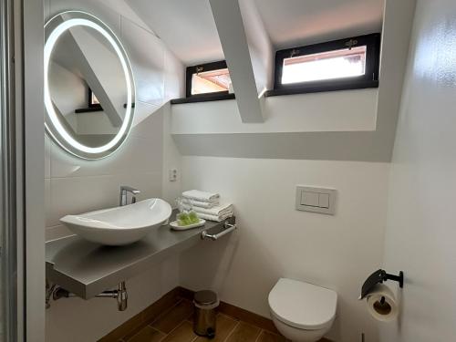 a white bathroom with a sink and a mirror at Boutique hotel Barvirna in Český Krumlov