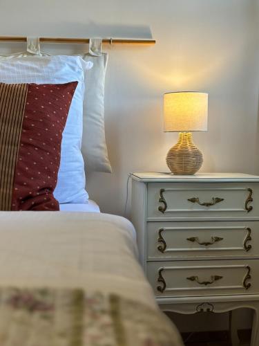 a bed with a night stand with a lamp on it at Boutique hotel Barvirna in Český Krumlov