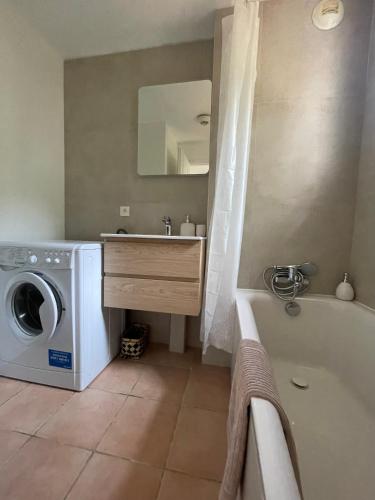 une salle de bain avec une machine à laver et un lave-linge dans l'établissement Maison Grimaud, à Grimaud
