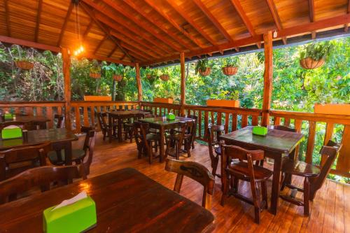 a restaurant with tables and chairs on a wooden deck at Hotel Tropical San Jeronimo in San Jerónimo