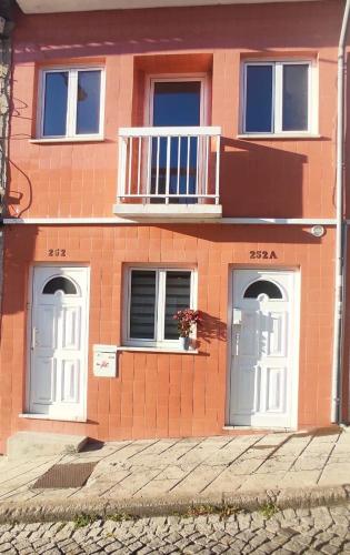 a brick house with two doors and a balcony at Casa Coral - Lodging & Culture in Braga