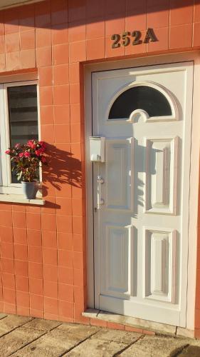 a white door on a brick building with a window at Casa Coral - Lodging & Culture in Braga