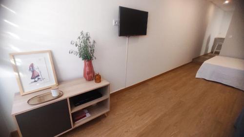 a living room with a tv on a wall at Casa Coral - Lodging & Culture in Braga