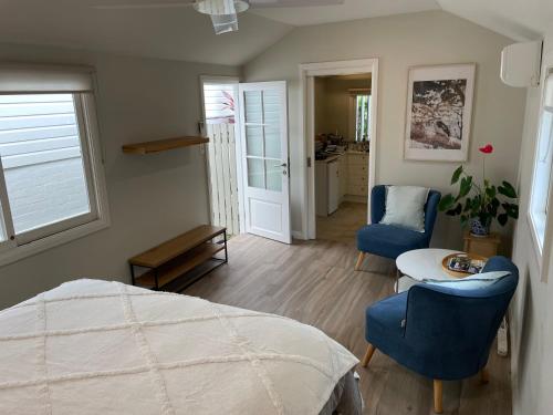 a bedroom with a bed and a table and chairs at Bryon's secret hideout studio in Byron Bay