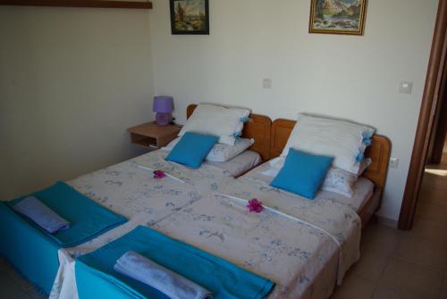 a bedroom with a bed with blue pillows at Manos House in Monólithos