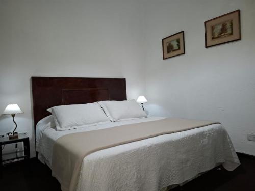a bedroom with a large bed with two pictures on the wall at La Teresita Hotel Boutique in Salta