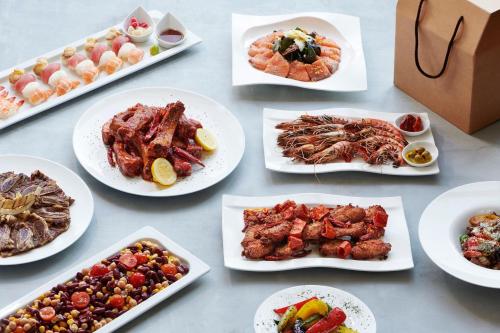 a table with many plates of food on it at Courtyard by Marriott Seoul Botanic Park in Seoul