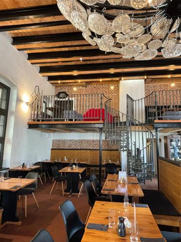 a restaurant with wooden tables and chairs and a ceiling at Boutique hotel Barvirna in Český Krumlov