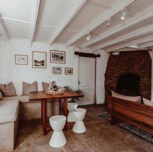 a living room with a couch and a table and a fireplace at Stanley Island in Plettenberg Bay