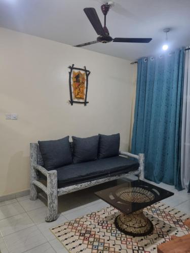 a living room with a blue couch and a table at Cessy's Apartments in Mtwapa