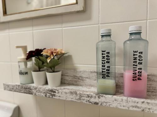 two bottles sitting on a shelf in a bathroom at Casa de pueblo cerca de Gredos y Navaluenga in Navalmoral