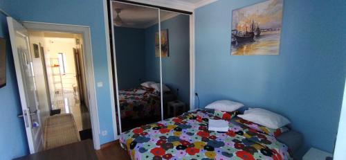 a blue bedroom with a bed and a mirror at Private Room 2 in Caneças