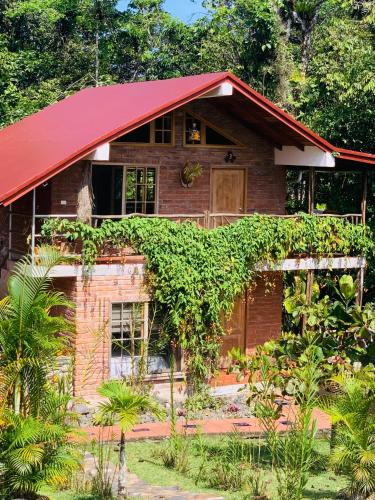 a brick house with a red roof at La Casa del Rio B&B in Puyo
