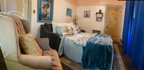 a bedroom with a bed and a couch and a chair at IreneHouse Victorian INN in Sacramento