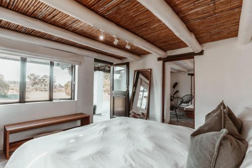 a bedroom with a white bed and a window at Stanley Island in Plettenberg Bay