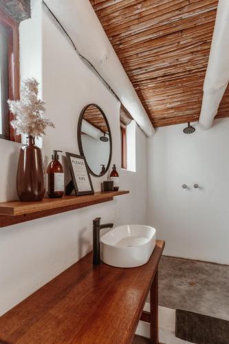 a bathroom with a white sink and a mirror at Stanley Island in Plettenberg Bay