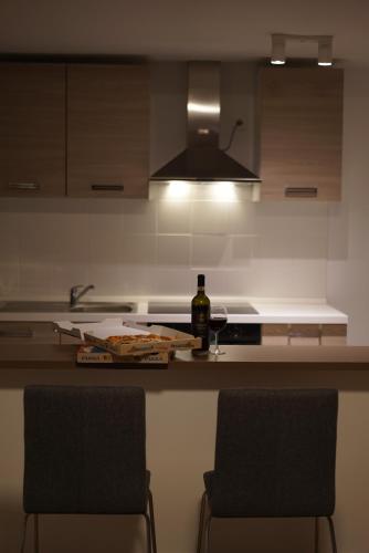 a kitchen with two chairs and a bottle of wine at Skyway airport apartments in Zaventem