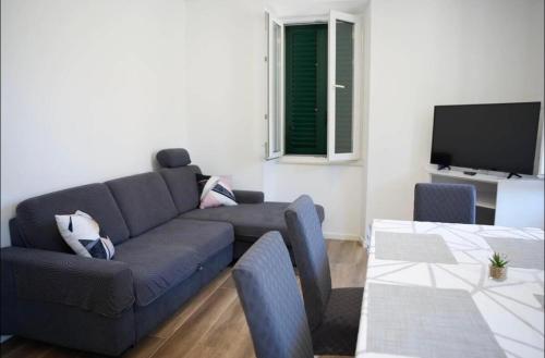 un soggiorno con divano e TV a schermo piatto di Apartmani Antonia a Račišće