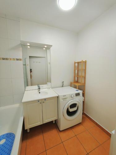 une salle de bain avec une machine à laver et un lavabo dans l'établissement Appartement 2P à Ivry, aux portes de paris avec parking privé, à Ivry-sur-Seine